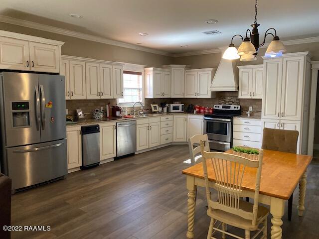 kitchen with a chandelier, backsplash, decorative light fixtures, and appliances with stainless steel finishes