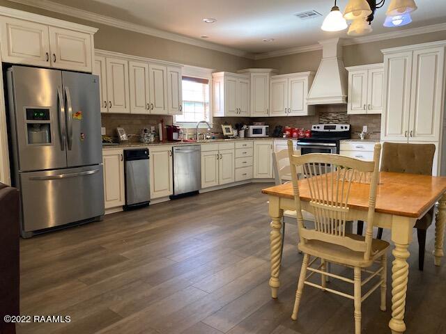 kitchen with premium range hood, tasteful backsplash, stainless steel appliances, and a notable chandelier