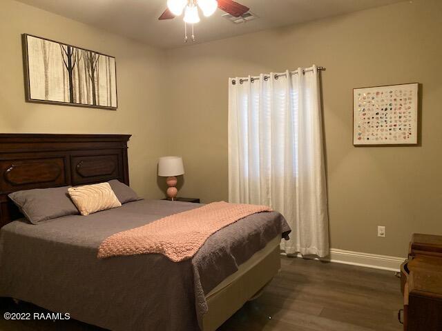 bedroom with ceiling fan and dark wood-type flooring