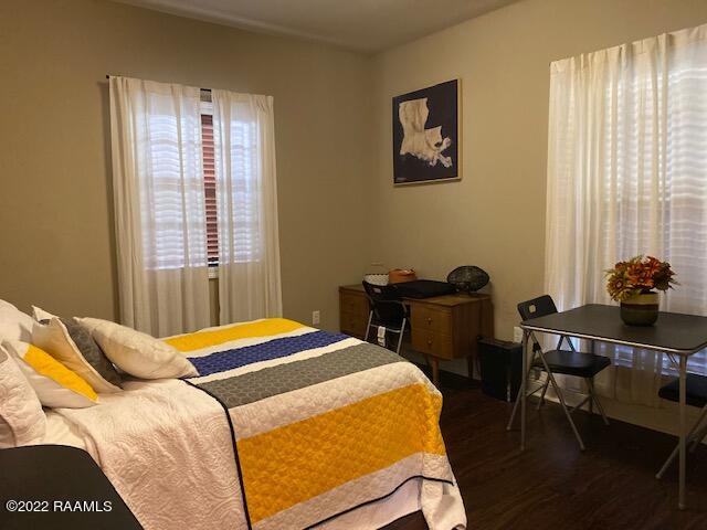 bedroom with dark wood-type flooring