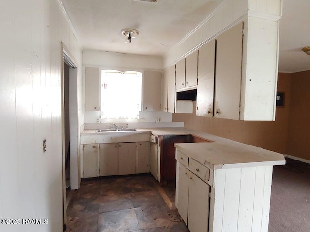 805 Edna St, New Iberia, LA 70560 - kitchen with white cabinets, a peninsula, light countertops, under cabinet range hood, and a sink