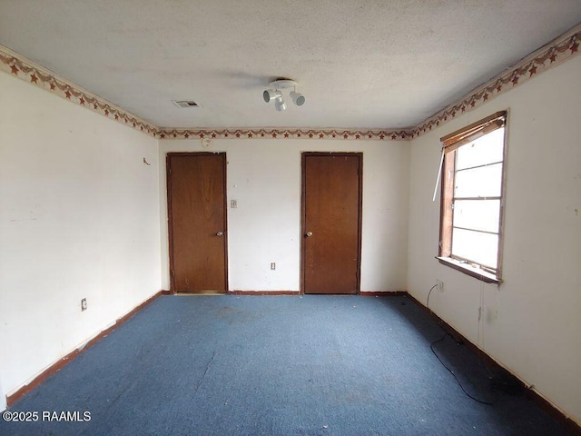 805 Edna St, New Iberia, LA 70560 - unfurnished bedroom featuring a textured ceiling, carpet floors, visible vents, baseboards, and a closet