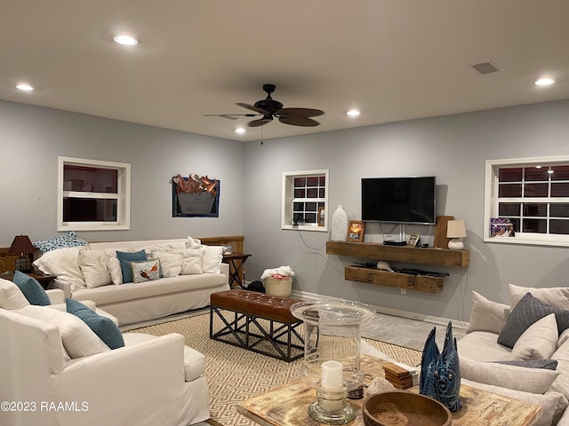 carpeted living room with ceiling fan