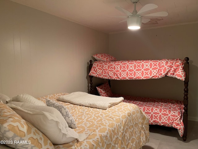 carpeted bedroom with ornamental molding and ceiling fan