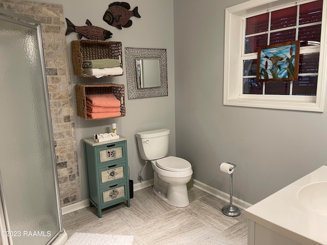 bathroom featuring toilet, vanity, a shower with door, and tile flooring