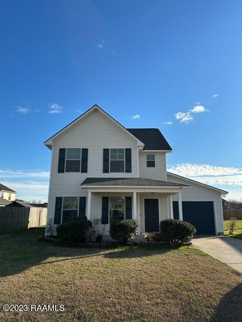 front of property featuring covered porch, a front yard, and a garage