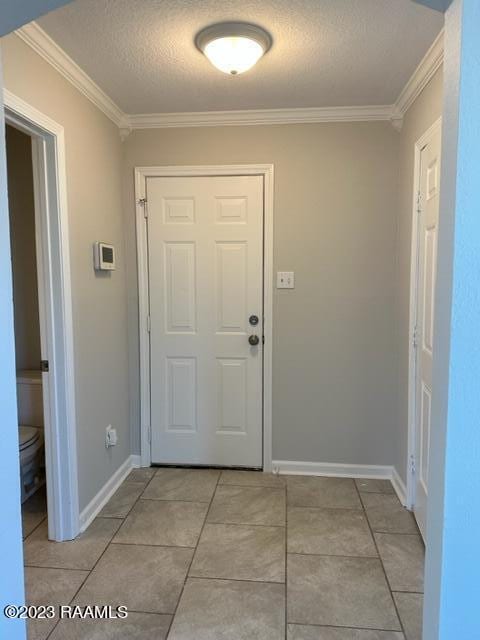 doorway featuring light tile floors, a textured ceiling, and crown molding