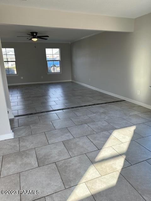 tiled empty room with ceiling fan and a wealth of natural light