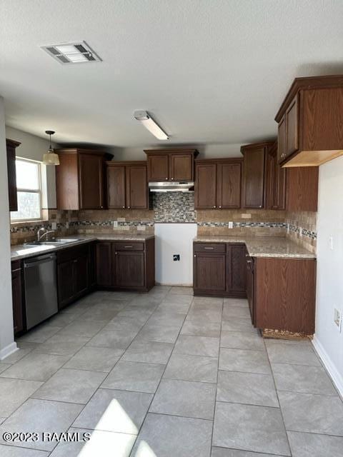 kitchen with light stone counters, tasteful backsplash, stainless steel dishwasher, light tile floors, and hanging light fixtures