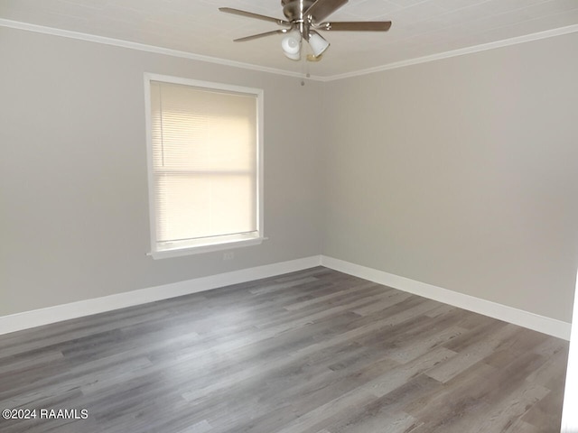 empty room featuring ceiling fan, ornamental molding, and dark wood-type flooring