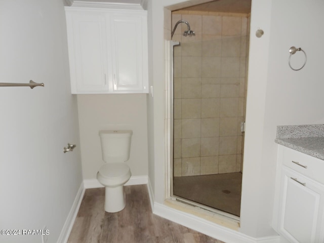 bathroom featuring vanity, toilet, hardwood / wood-style flooring, and an enclosed shower