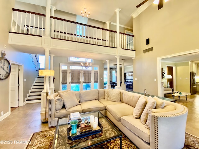 living room with light tile flooring, ornate columns, ceiling fan with notable chandelier, a towering ceiling, and french doors