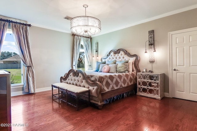 bedroom featuring a chandelier, dark wood-type flooring, and crown molding