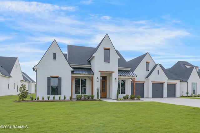 modern farmhouse featuring a garage and a front lawn