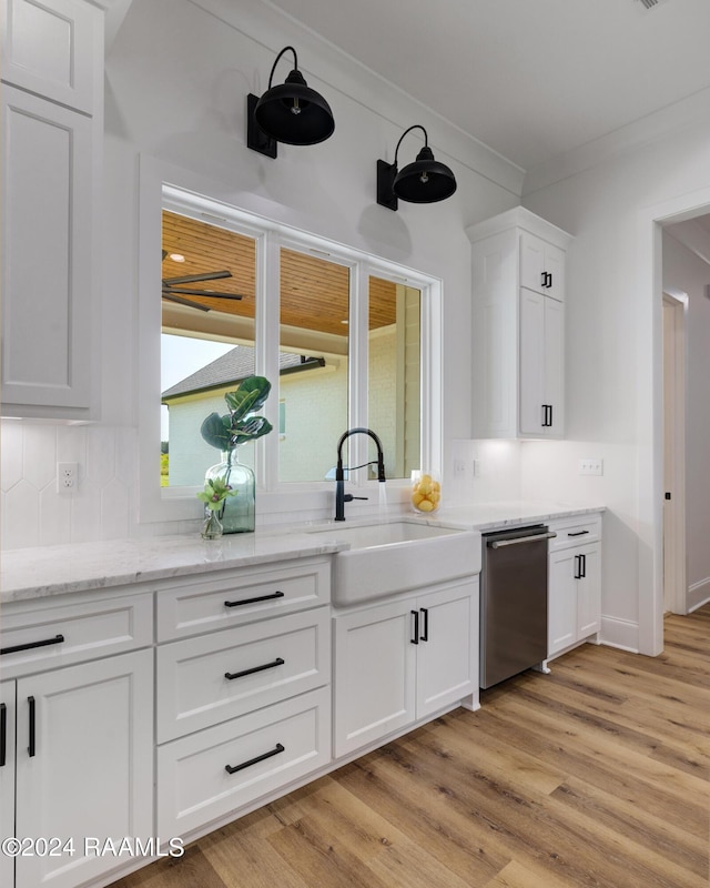 bar featuring stainless steel dishwasher, ornamental molding, sink, white cabinets, and light hardwood / wood-style floors