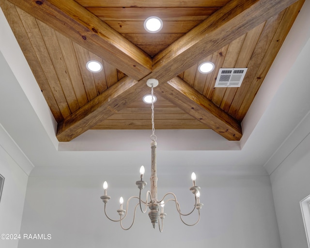 interior details with a notable chandelier, beam ceiling, wooden ceiling, and crown molding