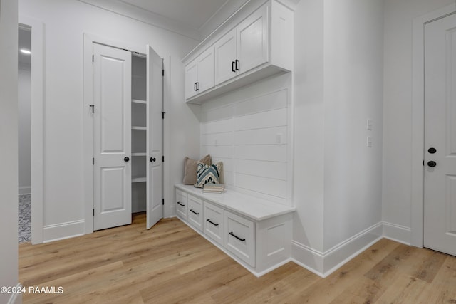 mudroom featuring light wood-type flooring and ornamental molding