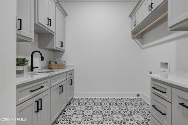 laundry room featuring cabinets, hookup for a washing machine, hookup for an electric dryer, sink, and light tile patterned floors