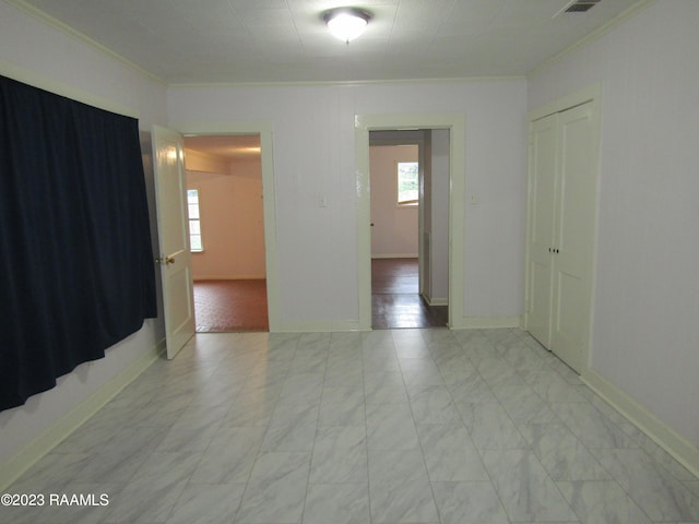 empty room with ornamental molding and light hardwood / wood-style floors