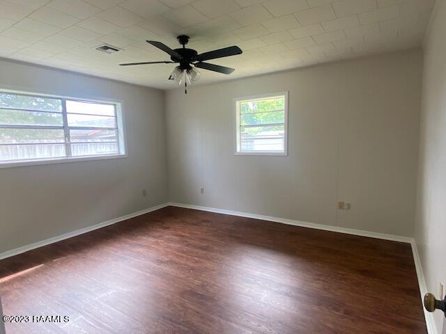 unfurnished room featuring ceiling fan and dark wood-type flooring