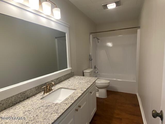 full bathroom featuring shower / washtub combination, toilet, hardwood / wood-style flooring, and vanity