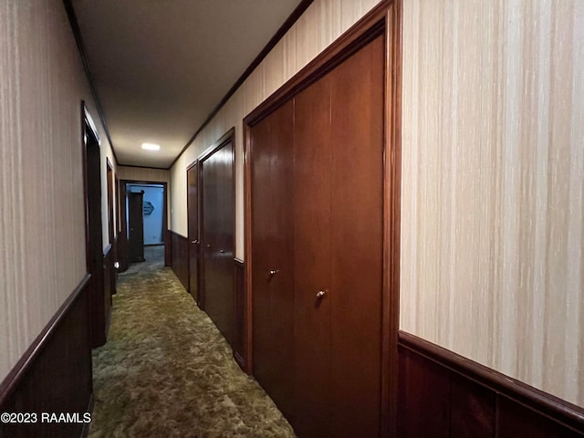 corridor featuring dark colored carpet