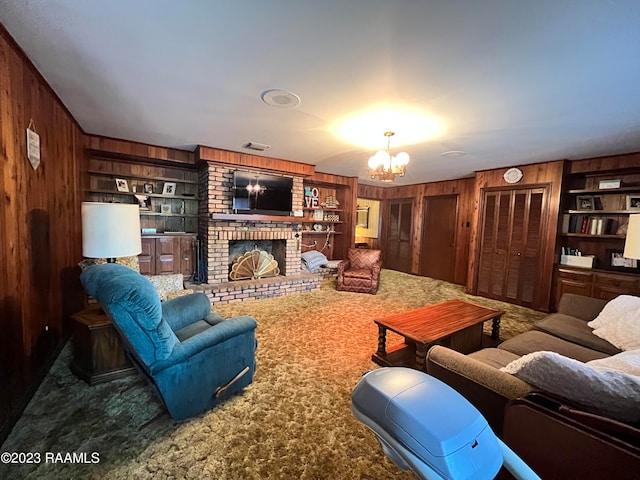 carpeted living room featuring an inviting chandelier, wooden walls, built in shelves, and a brick fireplace