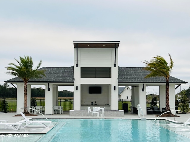 back of property with a community pool and a patio