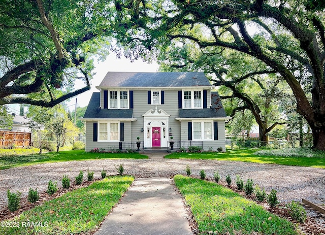 colonial inspired home featuring a front lawn