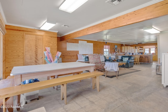 misc room featuring ceiling fan, wooden walls, and ornamental molding