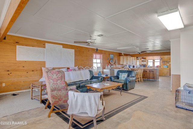 living room featuring ceiling fan and wooden walls