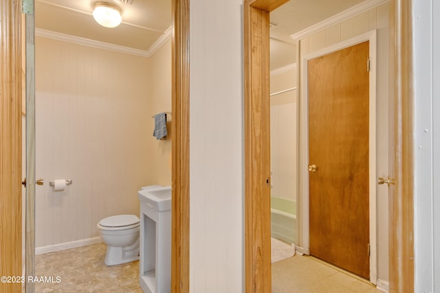 bathroom with ornamental molding,  shower combination, toilet, and tile floors