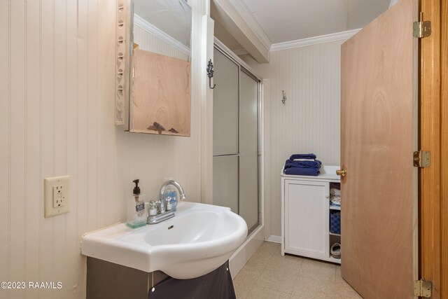 bathroom featuring crown molding, sink, tile floors, and a shower with shower door