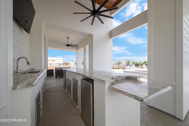 view of patio with area for grilling, ceiling fan, and an outdoor wet bar