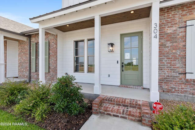 view of exterior entry with a porch