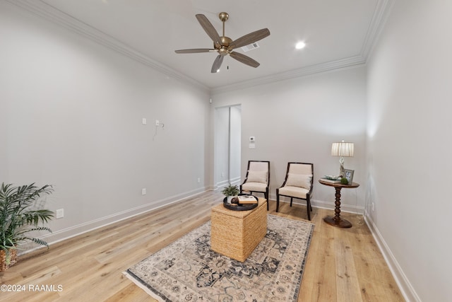 sitting room with ceiling fan, ornamental molding, and light hardwood / wood-style flooring