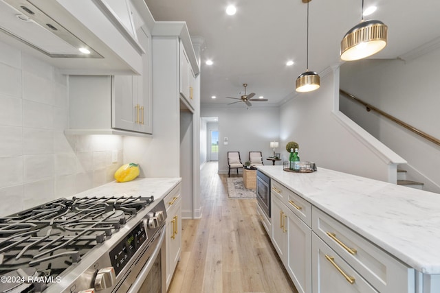 kitchen with white cabinetry, light hardwood / wood-style flooring, hanging light fixtures, and appliances with stainless steel finishes