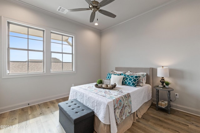 bedroom with wood-type flooring, ceiling fan, and ornamental molding