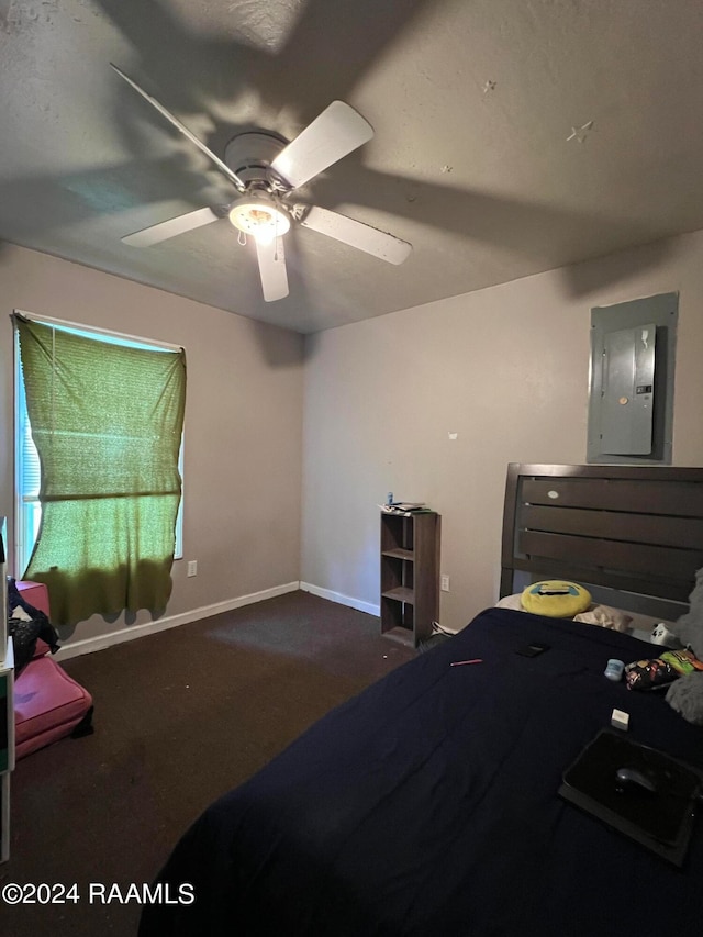 bedroom with dark colored carpet, ceiling fan, and electric panel