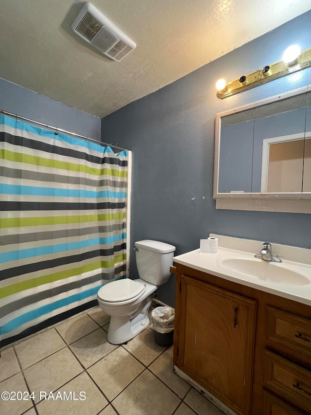 bathroom with vanity, tile patterned flooring, toilet, and a textured ceiling