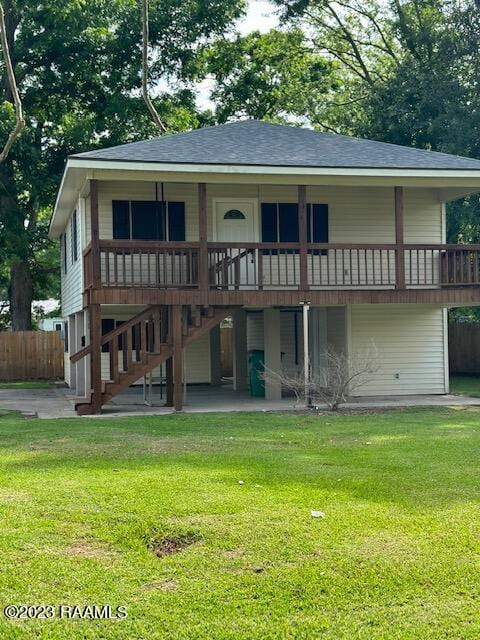 back of property featuring a deck, a yard, and a patio