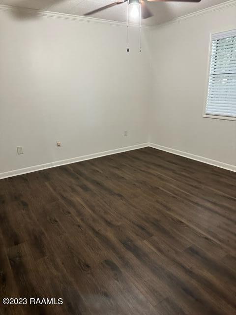 unfurnished room with ceiling fan, dark hardwood / wood-style flooring, and ornamental molding