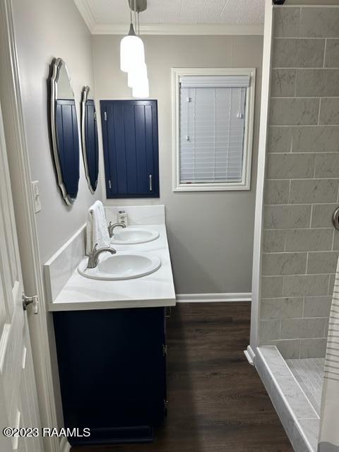 bathroom featuring a shower, vanity, hardwood / wood-style flooring, and crown molding