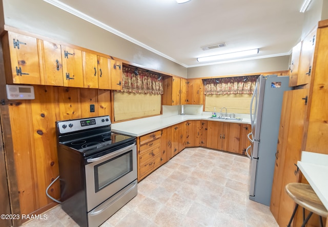 kitchen with light tile floors, appliances with stainless steel finishes, sink, and ornamental molding