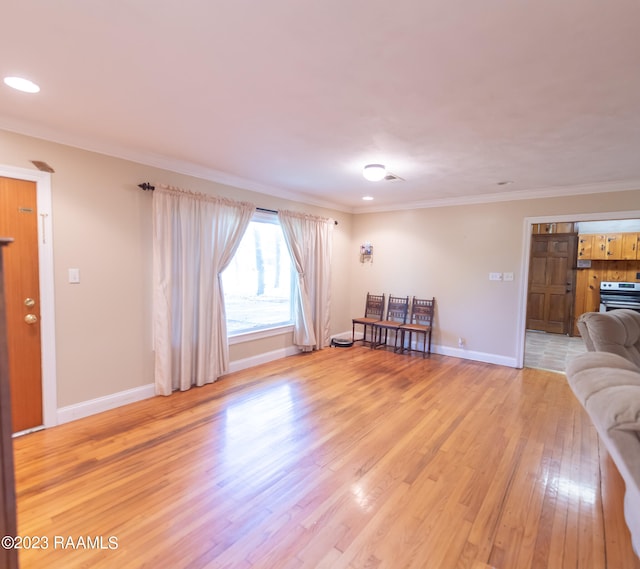 living room featuring crown molding and light hardwood / wood-style floors