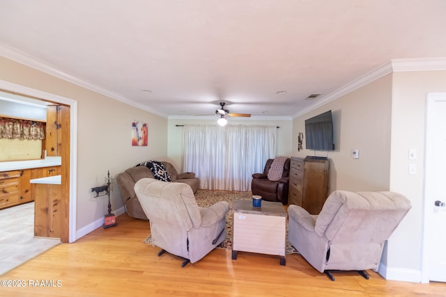 living room with ceiling fan, light wood-type flooring, and ornamental molding