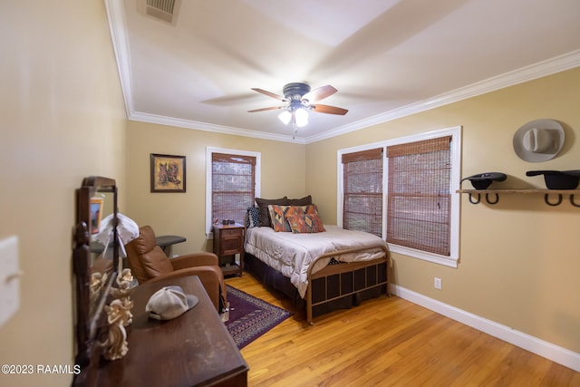 bedroom featuring ceiling fan, crown molding, and light hardwood / wood-style floors