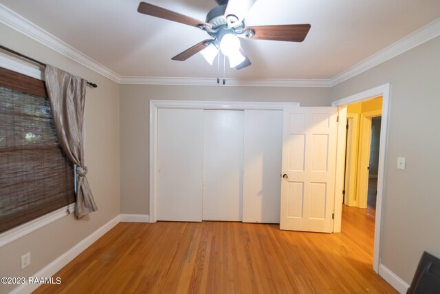 unfurnished bedroom with ornamental molding, ceiling fan, a closet, and light hardwood / wood-style flooring