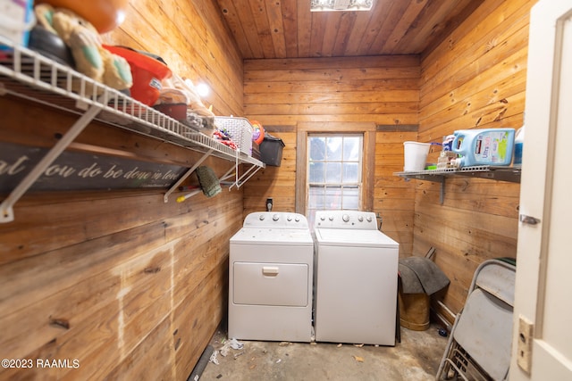 washroom with wood walls and separate washer and dryer