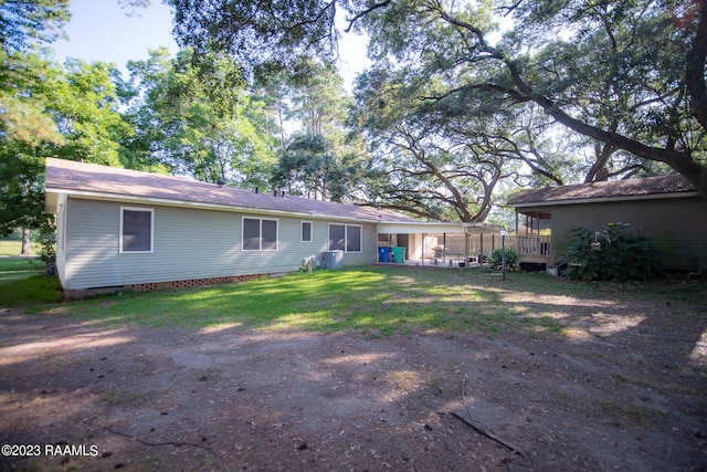 back of property featuring a lawn and a wooden deck